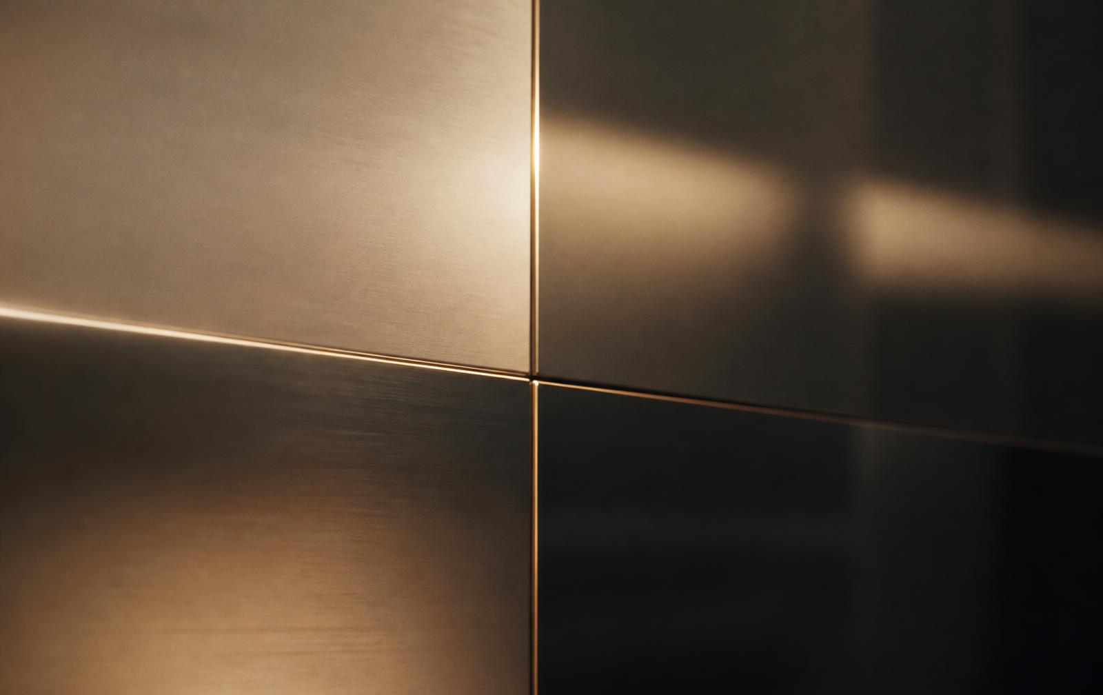 Brushed metal and dark glass surfaces forming a quiet grid